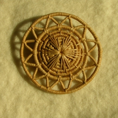 Foto på brosch gjord  björkrötter. Photo of brooch made from birch roots.